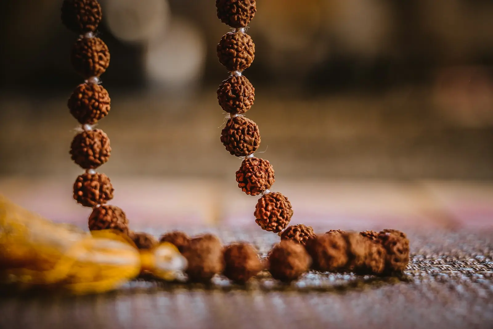 A rudraksha mala lying on a woven mat